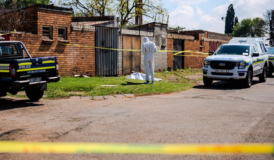 A forensic officer works at the scene where a sixth body, believed to be that of a woman, was found along a road in KwaThema, Springs, South Africa, Tuesday, Sept. 15, 2026. (AP Photo)