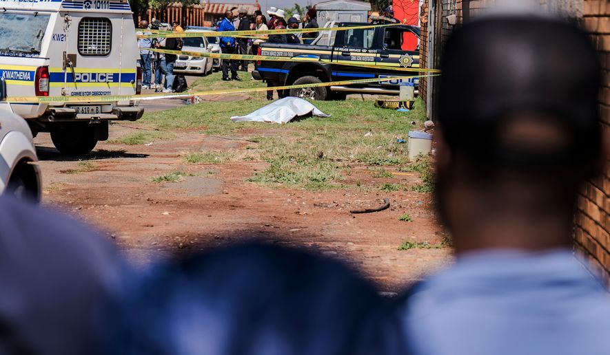 A body, believed to be that of a woman, is found along a road in KwaThema, Springs, South Africa, Tuesday, Sept. 15, 2026. (AP Photo)