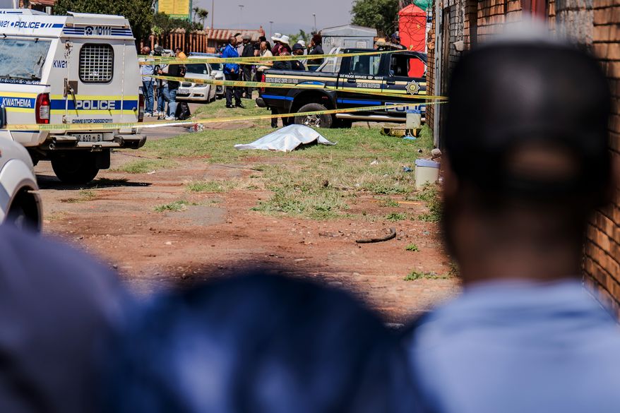 A body, believed to be that of a woman, is found along a road in KwaThema, Springs, South Africa, Tuesday, Sept. 15, 2026. (AP Photo)