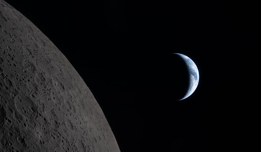 In this image provided by NASA, the Artemis II crew captured this view of the Earth next to the Moon before Earthset during a lunar flyby, Monday, April 6, 2026. (NASA via AP)