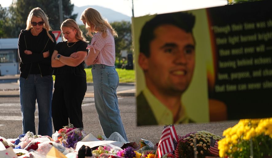 FILE - Women pray at a memorial outside Utah Valley University after Turning Point USA CEO and co-founder Charlie Kirk was shot and killed, Sept. 13, 2025, in Orem, Utah. (AP Photo/Lindsey Wasson, File)