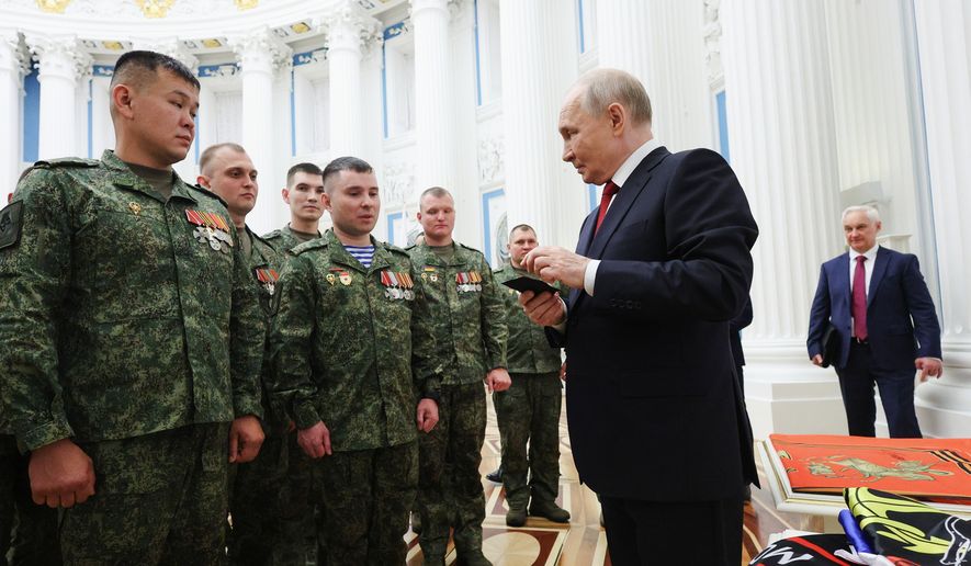 Russian President Vladimir Putin, foreground right, speaks with members of the military in the Kremlin in Moscow on Friday, June 12, 2026, as Defense Minister Andrei Belousov, right, stands nearby. (Vyacheslav Prokofyev, Sputnik, Kremlin Pool Photo via AP) **FILE**