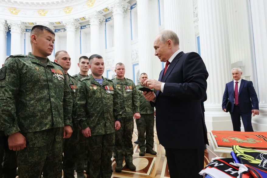 Russian President Vladimir Putin, foreground right, speaks with members of the military in the Kremlin in Moscow on Friday, June 12, 2026, as Defense Minister Andrei Belousov, right, stands nearby. (Vyacheslav Prokofyev, Sputnik, Kremlin Pool Photo via AP) **FILE**