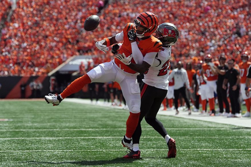 Cincinnati Bengals wide receiver Ja'marr Chase (1) can't hang onto a pass as he is defended by Tampa Bay Buccaneers cornerback Jacob Parrish (25) in the first half of an NFL football game Sunday, Sept. 13, 2026, in Cincinnati. (AP Photo/Joshua A. Bickel)