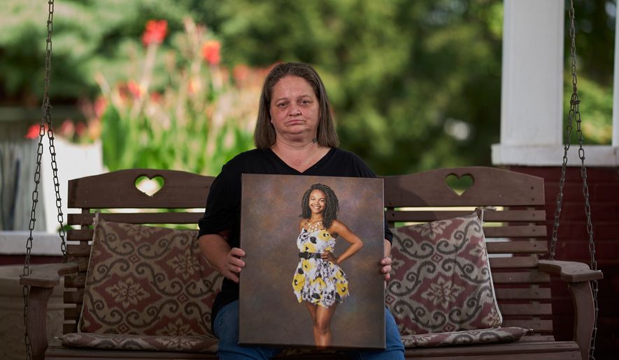 Christy Spivey poses with a portrait of her late daughter, Tasia Fortune, on Tuesday, Sept. 8, 2026, in Marion, Ky. (AP Photo/George Walker IV)