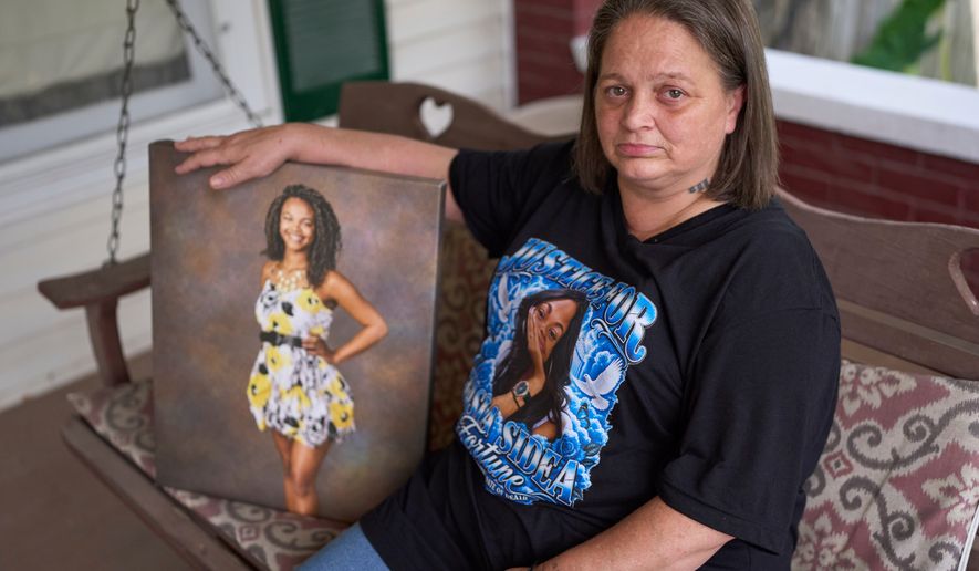 Christy Spivey poses with a portrait of her late daughter, Tasia Fortune, on Tuesday, Sept. 8, 2026, in Marion, Ky. (AP Photo/George Walker IV)
