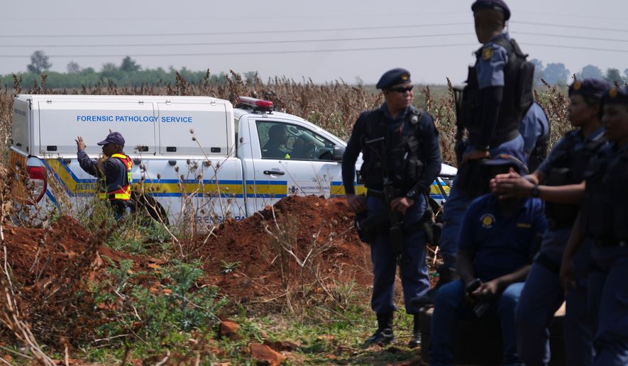 Forensic investigators work at the site where the body of a woman was discovered on the outskirts of Johannesburg, South Africa, Thursday, Sept. 17, 2026. (AP Photo/Themba Hadebe)