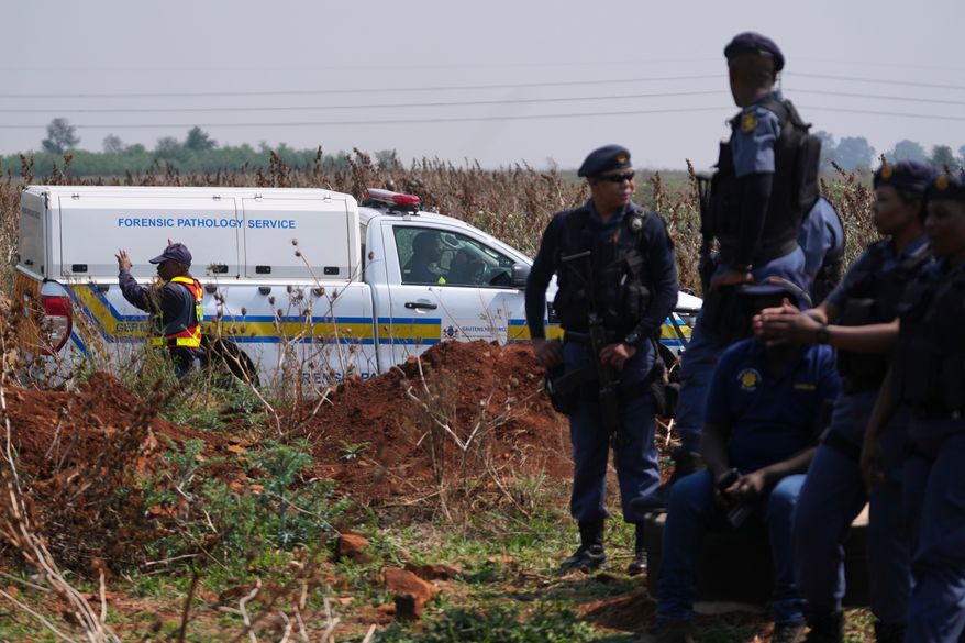 Forensic investigators work at the site where the body of a woman was discovered on the outskirts of Johannesburg, South Africa, Thursday, Sept. 17, 2026. (AP Photo/Themba Hadebe)