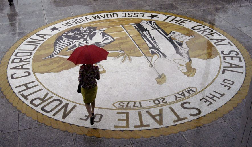 A woman carrying an umbrella leaves the N.C. Legislative Building in Raleigh, N.C., on Thursday, June 2, 2005. (AP Photo/Karen Tam)