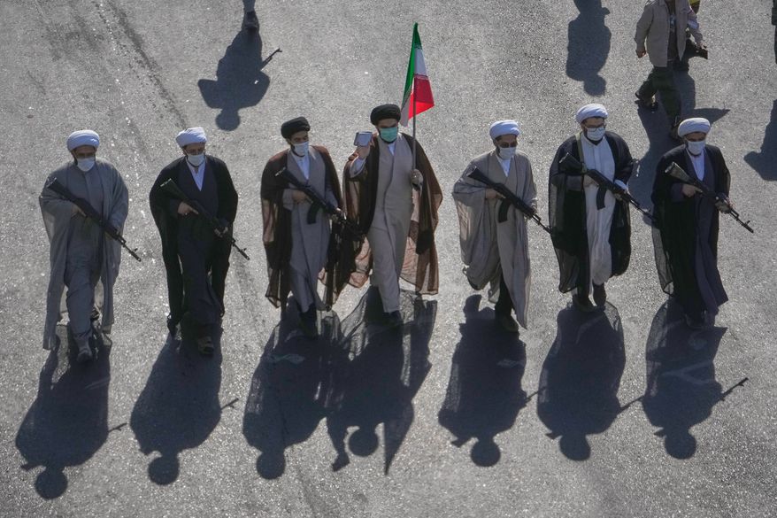 Shiite clerics carrying rifles march during the state-organized "Janfada," or "Sacrifice for Iran," military-style parade at Revolution Square in Tehran, Iran, Friday, Sept. 18, 2026. (AP Photo/Vahid Salemi)