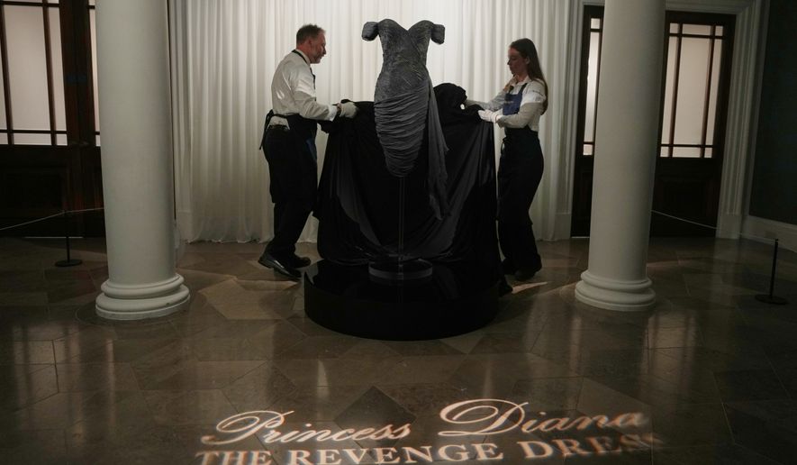 A dress worn by the late Princess Diana and known as the ''Revenge Dress'', designed by Christina Stambolian, is unveiled by staff at Sotheby’s auction house in London, Friday, Sept. 18, 2026, ahead of its Dec. 9 auction in New York, where it is estimated to sell for US$150,000-300,000. (AP Photo/Alastair Grant)