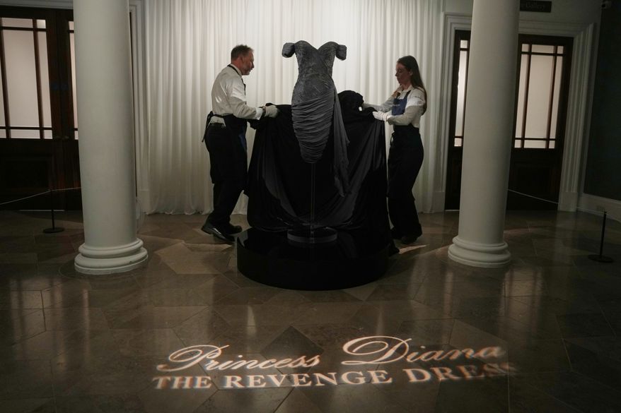 A dress worn by the late Princess Diana and known as the ''Revenge Dress'', designed by Christina Stambolian, is unveiled by staff at Sotheby’s auction house in London, Friday, Sept. 18, 2026, ahead of its Dec. 9 auction in New York, where it is estimated to sell for US$150,000-300,000. (AP Photo/Alastair Grant)