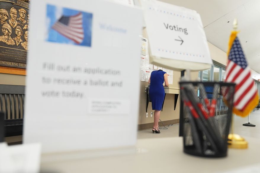 A voter fills out paperwork before casting a ballot on the first day of early voting in Minnesota at Maplewood City Hall, Friday, Sept. 18, 2026, in Maplewood, Minn. (AP Photo/Ellen Schmidt)