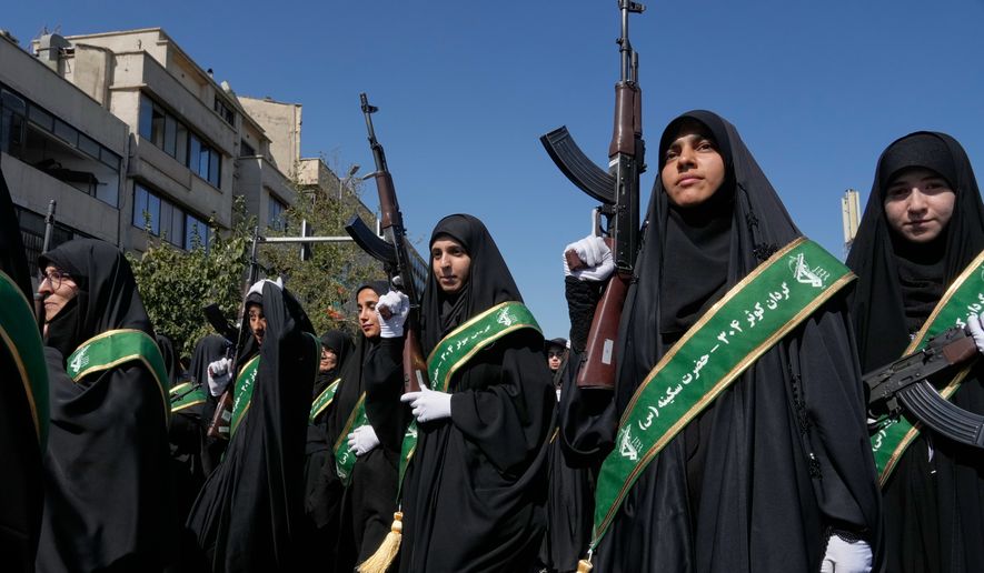 Women affiliated with Iran's Revolutionary Guard carry rifles as they participate in the state-organized "Janfada," or "Sacrifice for Iran," military-style parade in Tehran, Iran, Friday, Sept. 18, 2026. (AP Photo/Vahid Salemi)