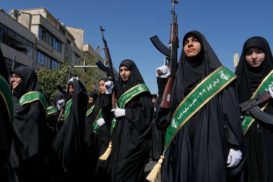 Women affiliated with Iran's Revolutionary Guard carry rifles as they participate in the state-organized "Janfada," or "Sacrifice for Iran," military-style parade in Tehran, Iran, Friday, Sept. 18, 2026. (AP Photo/Vahid Salemi)