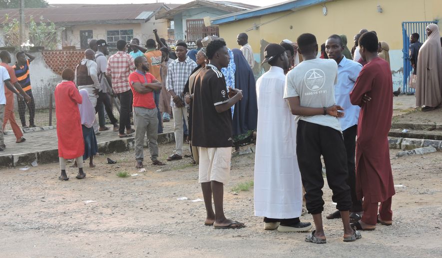 Families and relatives of miners who were arrested on suspicion of illegal mining wait outside a hospital where their bodies are stored in Minna, Nigeria, Thursday, Sept. 17, 2026. (AP Photo/Muhammed Nura)