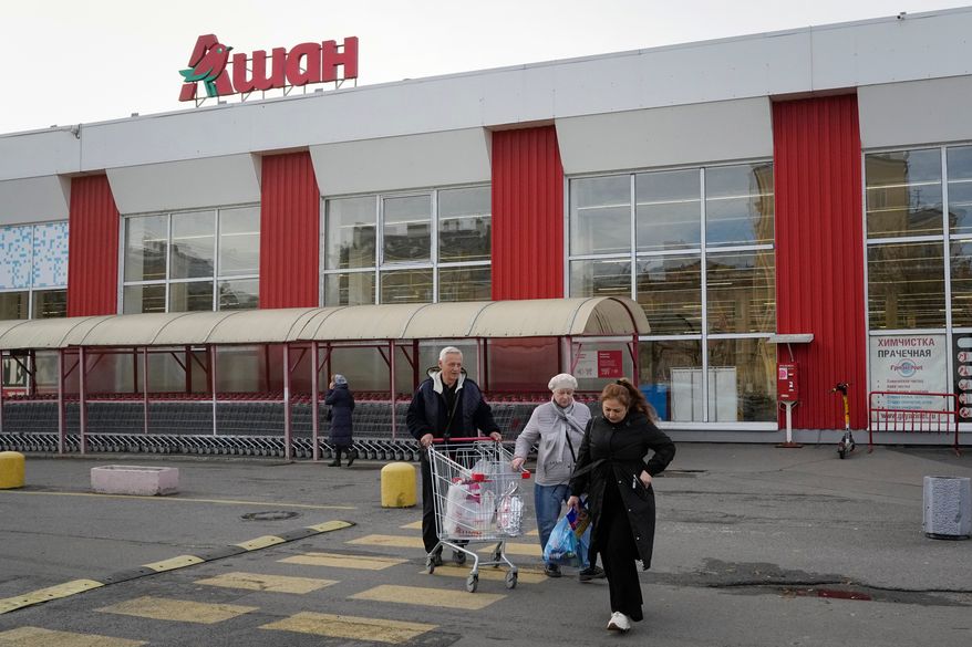 FILE - Customers walk after shopping in a store of the French retailer Auchan in St. Petersburg, Russia, Thursday, Oct. 24, 2024. (AP Photo/Dmitri Lovetsky, file)