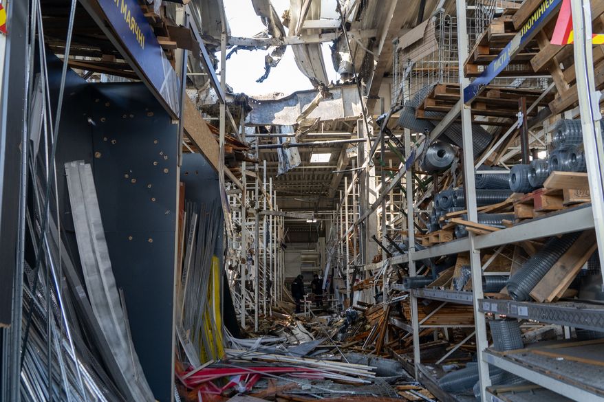 Police officers inspect a commercial facility damaged in a Russian drone attack in Kharkiv, Ukraine, Thursday, Sept. 17, 2026. (AP Photo/Andrii Marienko)