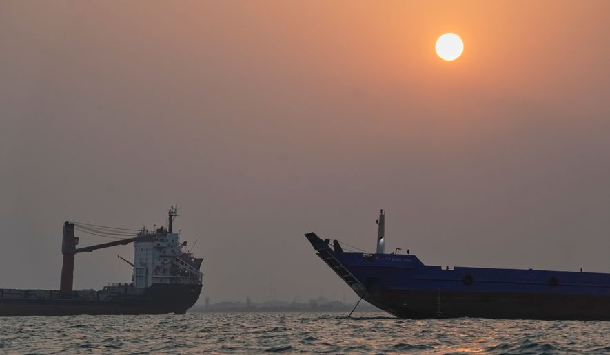 The sun sets over commercial vessels anchored in the Strait of Hormuz off Bandar Abbas, Iran, with the city's skyline in the background, Sunday, Sept. 6, 2026. (AP Photo/Vahid Salemi)