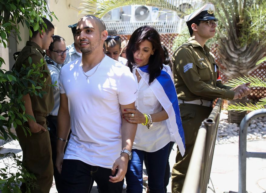 Elor Azaria escorted by his mother arrives to Israeli military court on July 30, 2017, in Tel Aviv, Israel. (AP Photo/Dan Balilty, Pool, File)