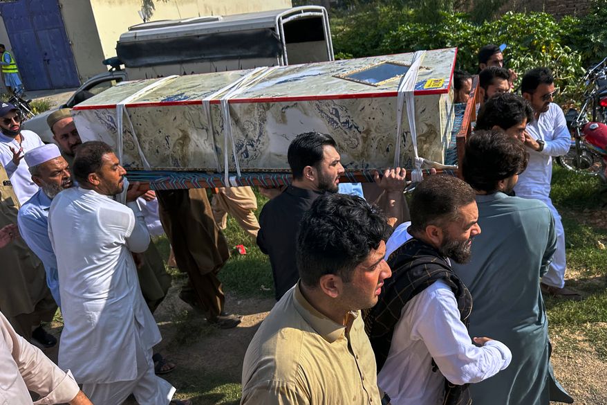 In this photo taken with a smartphone, mourners carry the casket of a victim who was killed in Friday's suicide bombing at a mosque, for a funeral in Kohat, in northwestern Pakistan, Saturday, Sept. 19, 2026. (AP Photo/Maaz Awan)