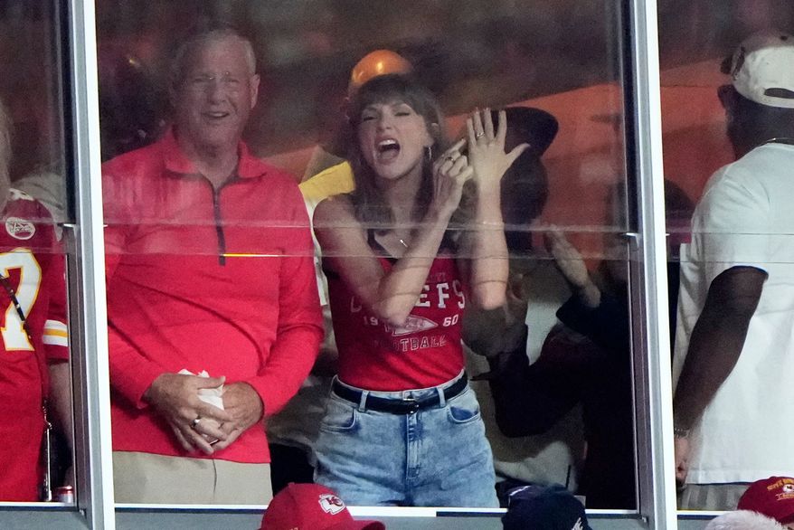 Taylor Swift celebrates with her father, Scott Swift, left, after a score by Kansas City Chiefs tight end Travis Kelce during the first half of an NFL football game between the Kansas City Chiefs and the Indianapolis Colts Sunday, Sept. 20, 2026, in Kansas City, Mo. (AP Photo/Charlie Riedel)