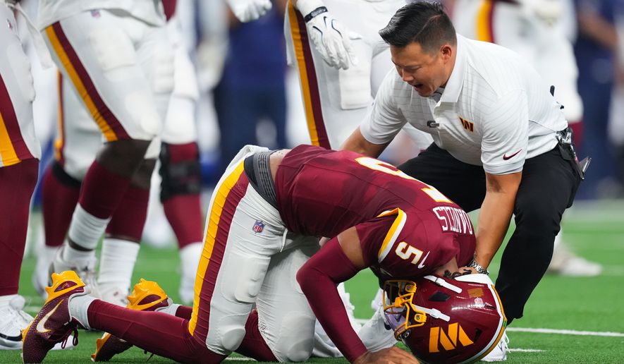 Washington Commanders quarterback Jayden Daniels (5) reacts after an apparent injury in the first half against the Dallas Cowboys during an NFL football game in Arlington, Texas, Sunday, Sept. 20, 2026. (AP Photo/Julio Cortez)