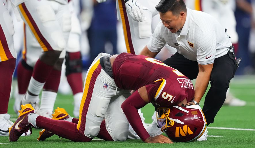Washington Commanders quarterback Jayden Daniels (5) reacts after an apparent injury in the first half against the Dallas Cowboys during an NFL football game in Arlington, Texas, Sunday, Sept. 20, 2026. (AP Photo/Julio Cortez)
