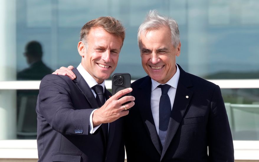 French President Emmanuel Macron, left, takes a selfie with Canadian Prime Minister Mark Carney after delivering remarks in Saint-Pierre, Saint-Pierre-et-Miquelon, Sunday, Sept.20, 2026. (Adrian Wyld/The Canadian Press via AP)