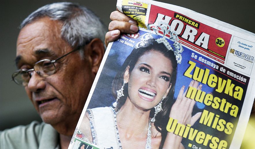 Retired teacher Manuel Colon Santiago, neighbor of the newly crowned Miss Universe Zuleyka Rivera Mendoza at her hometown of Salinas, Puerto Rico, shows a local newspaper with the headline: "Zuleyka our Miss Universe", Monday, July 24, 2006. People in this coastal town partied in the streets all night long to celebrate the crowning of the 18-year-old girl, after she was named Miss Universe late Sunday in Los Angeles. Several people in Salinas said Rivera, who grew up in a working-class neighborhood of small houses and narrow streets, never forgot her roots. (AP Photo/Herminio Rodriguez)