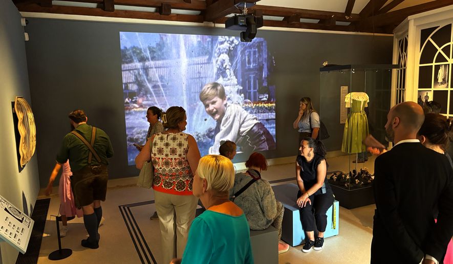 In this photo taken with a smartphone, people gather in the exhibition of the new "Sound Of Music Salzburg" museum in Salzburg, Austria, Sunday, Sept. 20, 2026. (AP Photo/Philipp-Moritz Jenne)