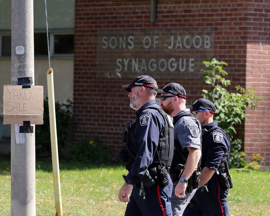 Police officers walk in front of the Son of Jacob Synagogue in Belleville, Ontario on Monday Sept. 21, 2026. (Ian MacAlpine/The Canadian Press via AP)