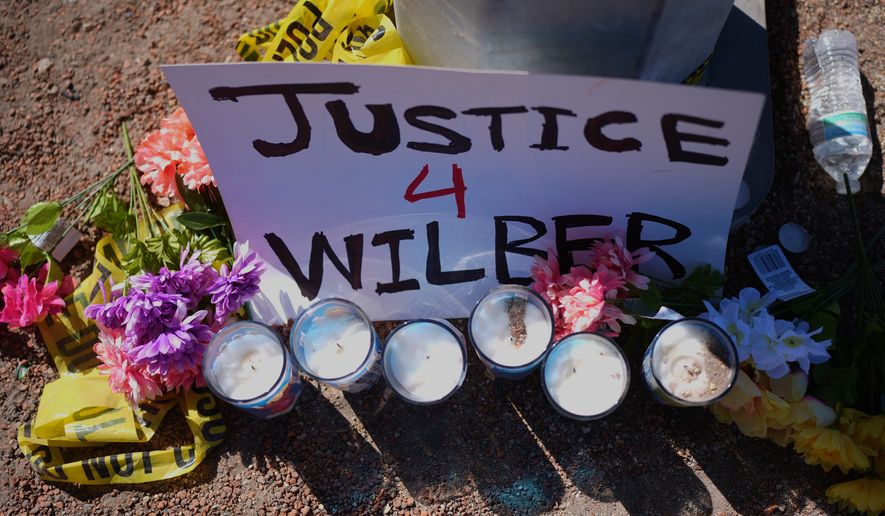 Flowers and candles are seen near the site where a Venezuelan man was shot in his vehicle by an ICE officer in Austin, Texas, Monday, Sept. 21, 2026. (AP Photo/Eric Gay)