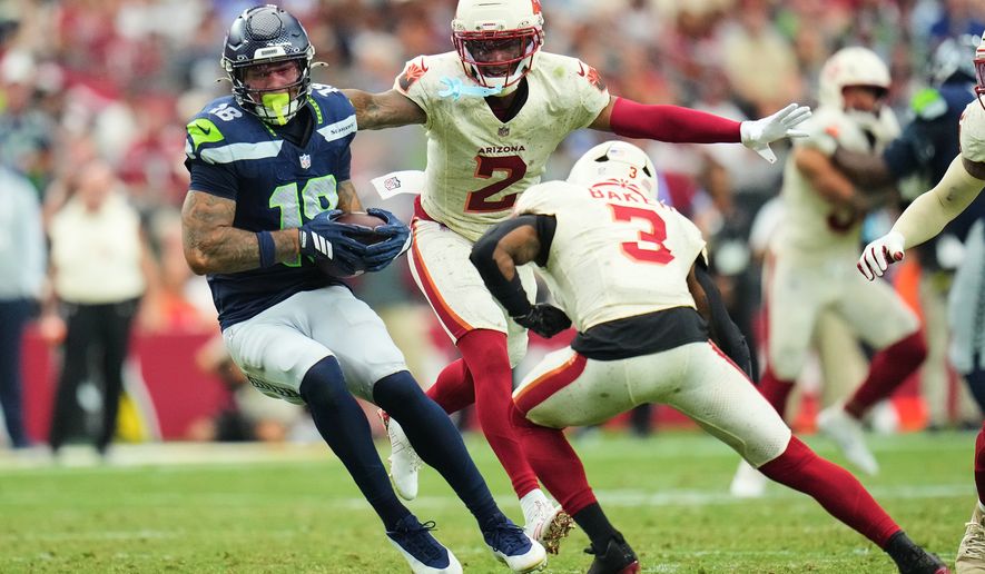 Seattle Seahawks tight end Elijah Arroyo (18) makes a catch against Arizona Cardinals cornerback Will Johnson (2) and safety Budda Baker (3) during the second half of an NFL football game in Glendale, Ariz., Sunday, Sept. 20, 2026. (AP Photo/Rick Scuteri)