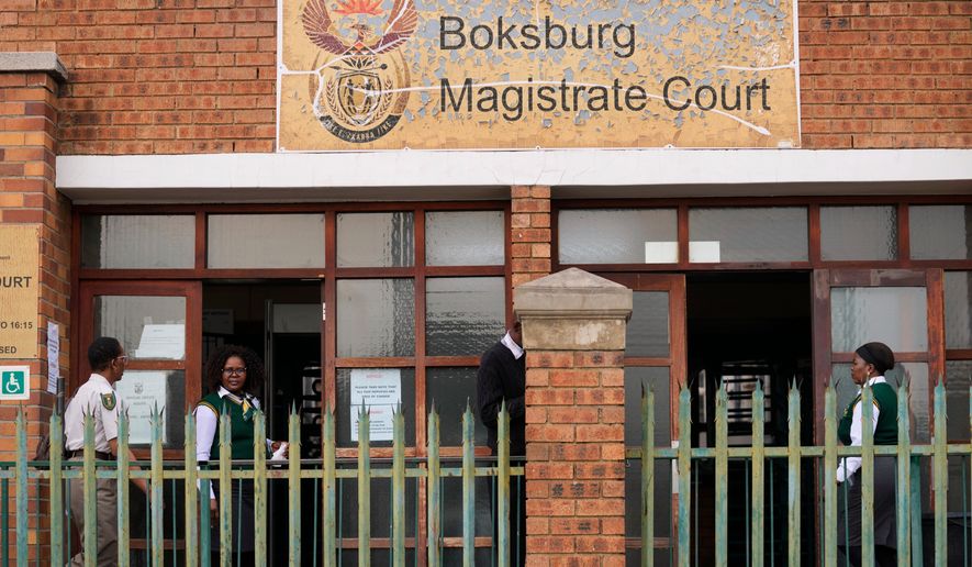 Court workers are seen at the entrance of the Boksburg Magistrate Court, east of Johannesburg, South Africa, Monday, Sept. 21, 2026, where suspects appeared in connection with one of a series of killings of women near Johannesburg. (AP Photo/Themba Hadebe)