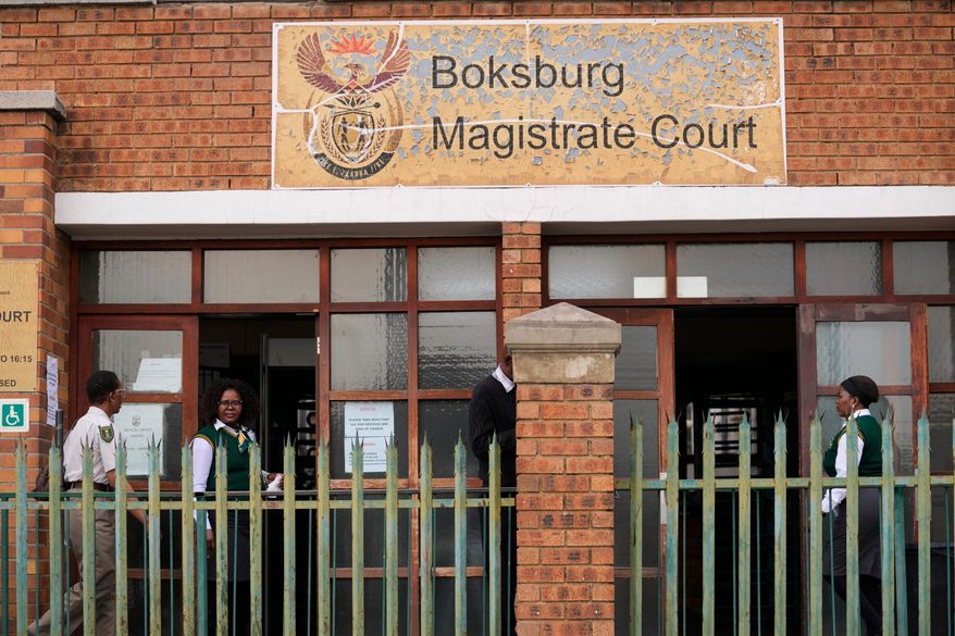 Court workers are seen at the entrance of the Boksburg Magistrate Court, east of Johannesburg, South Africa, Monday, Sept. 21, 2026, where suspects appeared in connection with one of a series of killings of women near Johannesburg. (AP Photo/Themba Hadebe)