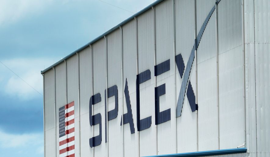 FILE - The SpaceX logo is displayed on a building, May 26, 2020, at the Kennedy Space Center in Cape Canaveral, Fla. (AP Photo/David J. Phillip, File)