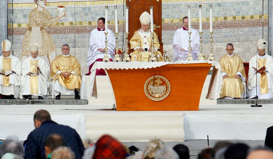 Pope Benedict XVI, center, celebrates a Mass in front of the Basilica of the Rosary in Lourdes, southwestern France, on Sept. 15, 2008. Behind him is one of the mosaics by Rev. Marko Ivan Rupnik, who was declared excommunicated in 2020 for committing one of the worst crimes in church law – using the confessional to absolve a woman with whom he had engaged in sexual activity. (AP Photo/Alessandra Tarantino, File)