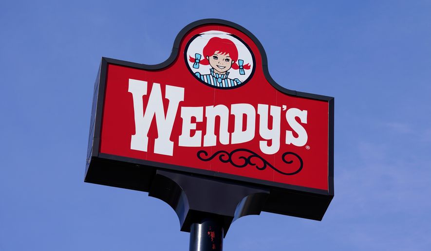FILE - A sign stands over a Wendy's restaurant, Feb. 25, 2021, in Des Moines, Iowa. (AP Photo/Charlie Neibergall, File)