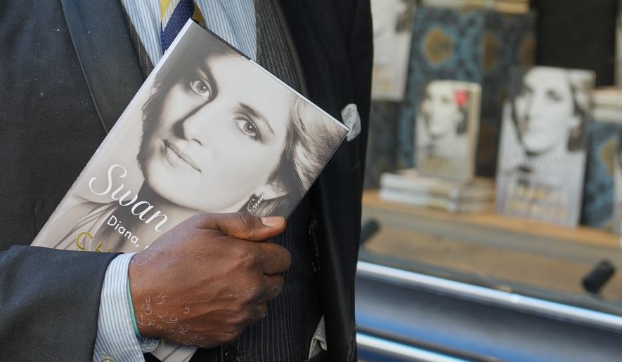 A man holds a copy of the new book by Earl Spencer, brother of the late Princess Diana, entitled "Swan Song: Diana, My Sister," outside a bookshop in central London, Tuesday, Sept. 22, 2026. (AP Photo/Kin Cheung)