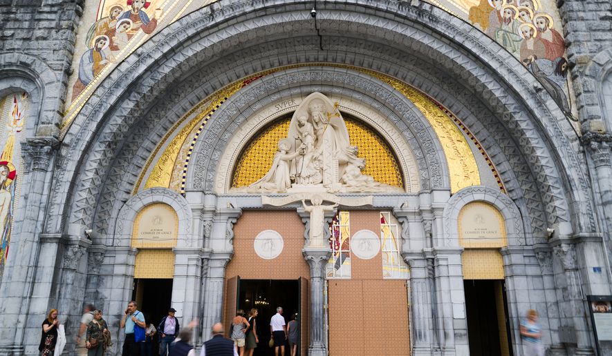 People enter the Notre-Dame-du-Rosaire basilica in Lourdes, southwestern France, Tuesday Sept. 8, 2026 . (AP Photo/Fred Scheiber)