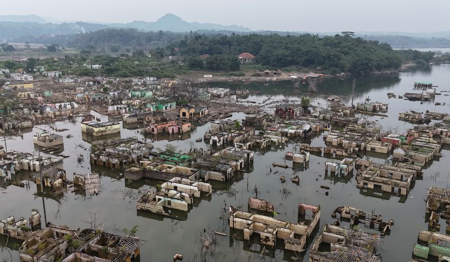 Long-submerged houses are exposed after prolonged drought lowers the water level of Karian Dam, in Lebak, Banten Province, Indonesia, Friday, July 31, 2026. (AP Photo/Tatan Syuflana)