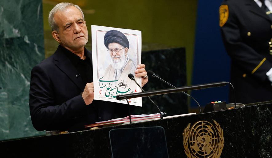 Iran's President Masoud Pezeshkian holds an image of late Iranian Supreme Leader Ayatollah Ali Khamenei during the 81st session of the United Nations General Assembly at United Nations headquarters, Wednesday, Sept. 23, 2026. (AP Photo/Stefan Jeremiah)