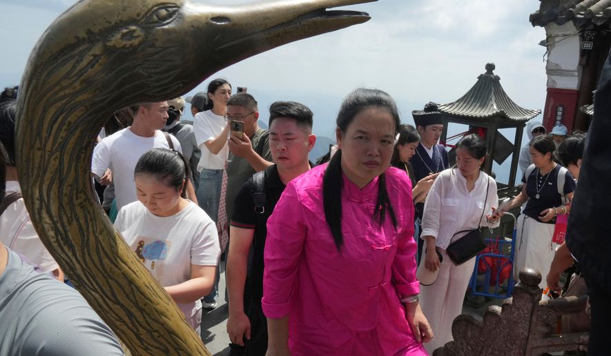 Visitors line up to pray at the Golden Hall in Wudang Mountains in central China's Hubei Province on Sept. 3, 2026. (AP Photo/Achmad Ibrahim)