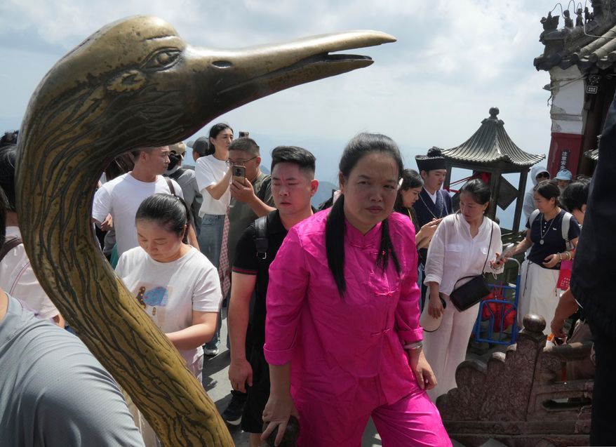 Visitors line up to pray at the Golden Hall in Wudang Mountains in central China's Hubei Province on Sept. 3, 2026. (AP Photo/Achmad Ibrahim)