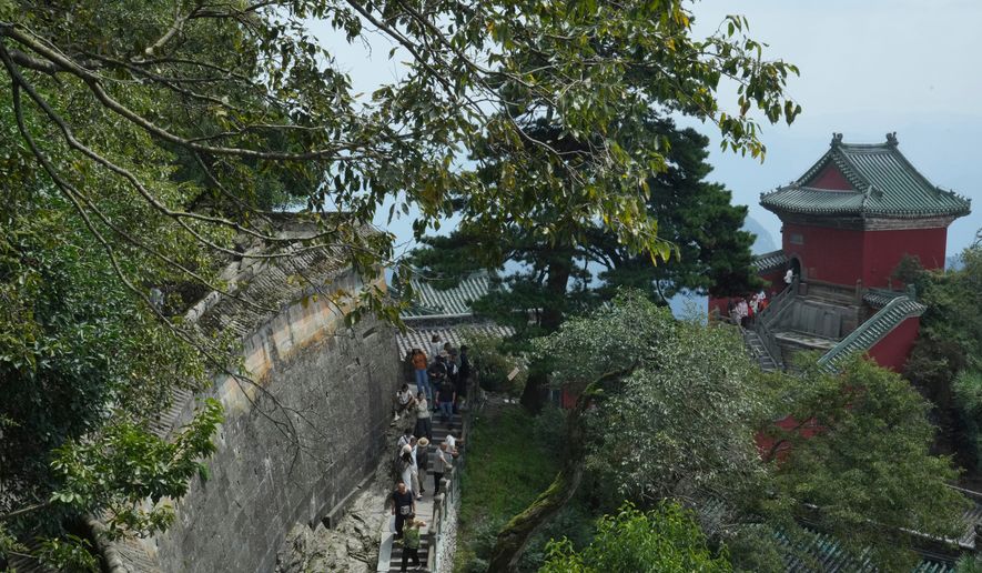 Visitors walk near a temple in Wudang Mountains in central China's Hubei Province on Sept. 3, 2026. (AP Photo/Achmad Ibrahim)