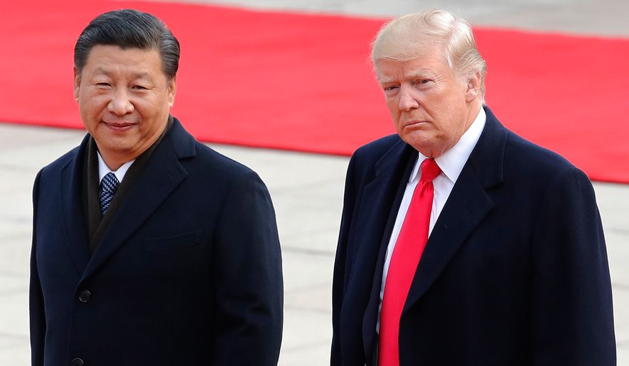 FILE - President Donald Trump, right, walks with Chinese President Xi Jinping during a welcome ceremony at the Great Hall of the people in Beijing, Nov. 9, 2017. (AP Photo/Andy Wong, File)