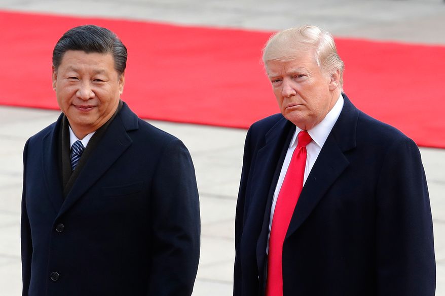 FILE - President Donald Trump, right, walks with Chinese President Xi Jinping during a welcome ceremony at the Great Hall of the people in Beijing, Nov. 9, 2017. (AP Photo/Andy Wong, File)