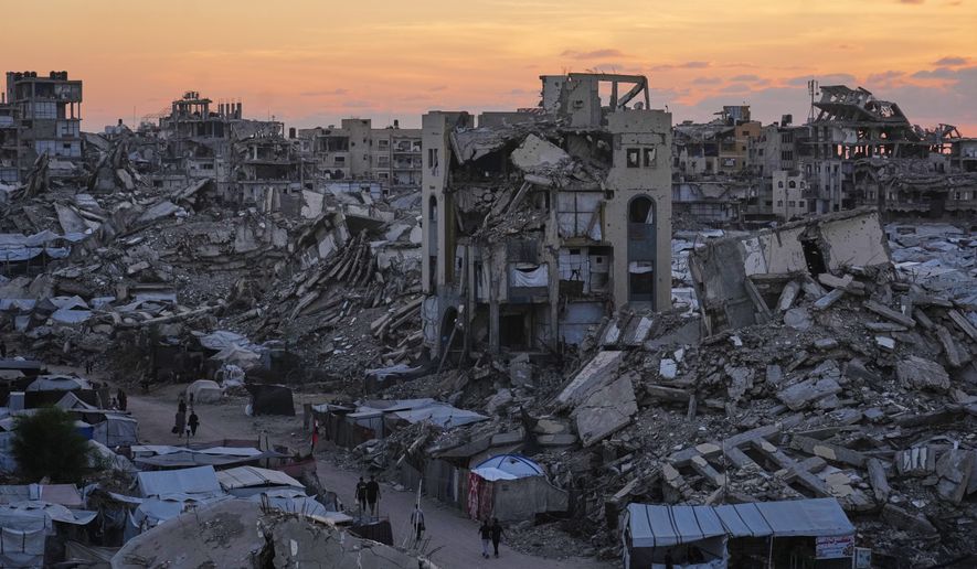 Palestinians walk amid war-damaged buildings in Gaza City, Wednesday, Sept. 23, 2026. (AP Photo/Jehad Alshrafi)