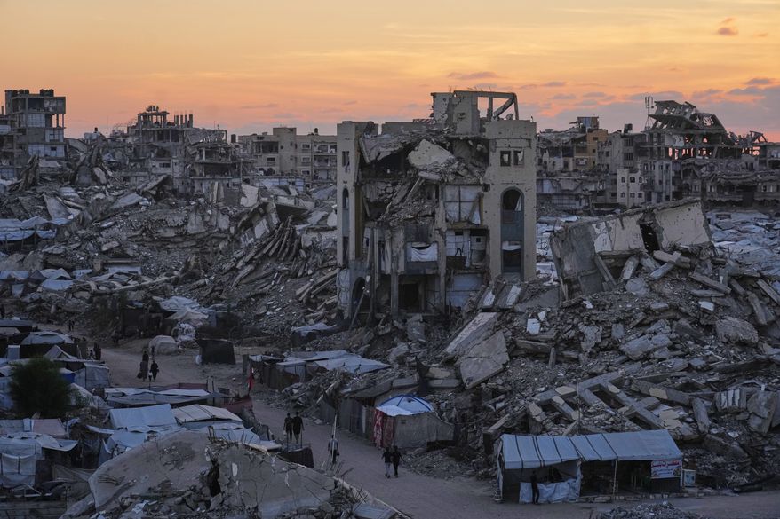 Palestinians walk amid war-damaged buildings in Gaza City, Wednesday, Sept. 23, 2026. (AP Photo/Jehad Alshrafi)
